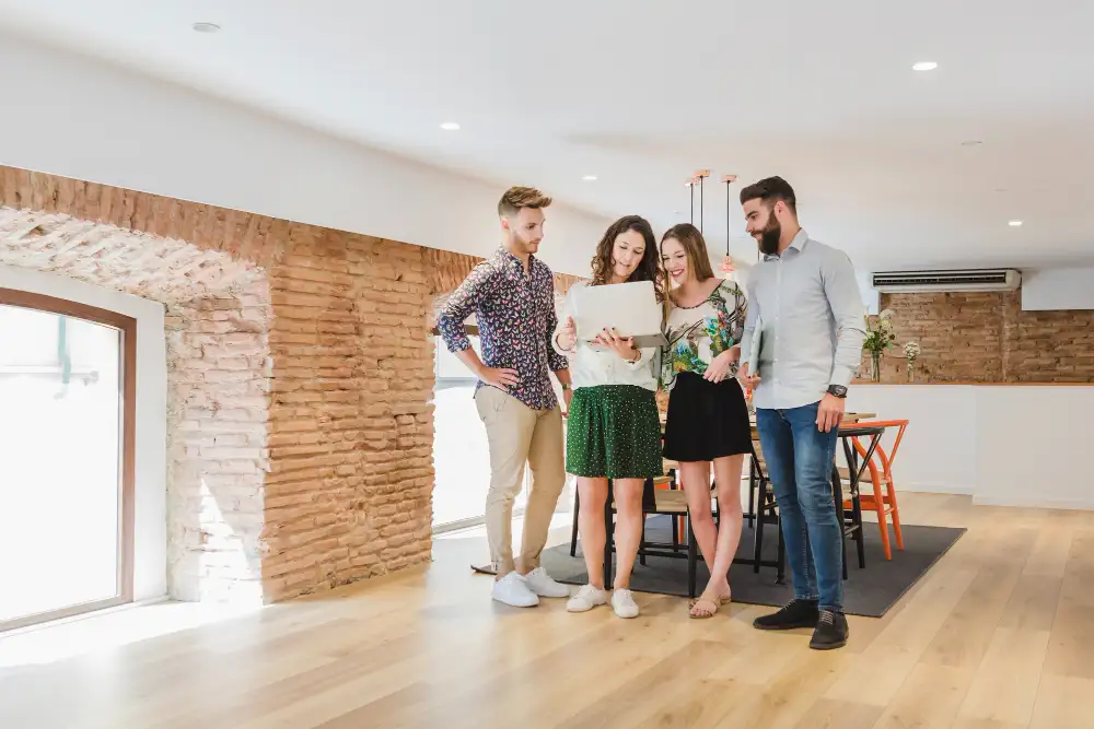 dos parejas en una casa compartiendo información en un ordenador